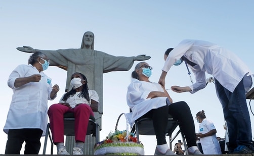 Terezinha da Conceicao, 80, left, and Dulcinea da Silva Lopes, 59, get vaccinated in front of the Christ the Redeemer statue in Rio de Janeiro, Brazil. Data in recent weeks on new variants from South Africa and Brazil has undercut optimism sparked late last year by two vaccines with around 95% efficacy against Covid-19. (AP Photo) Terezinha da Conceicao, 80, left, and Dulcinea da Silva Lopes, 59, get vaccinated in front of the Christ the Redeemer statue in Rio de Janeiro, Brazil. Data in recent weeks on new variants from South Africa and Brazil has undercut optimism sparked late last year by two vaccines with around 95% efficacy against Covid-19. (AP Photo)
