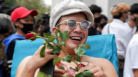 Musician and activist Chaiamorn "Ammy" Kaewwiboonpan, 32, receives roses as he arrives to report himself on royal insult charges, at the Attorney General's office in Bangkok, Thailand February 17, 2021. Picture taken February 17, 2021. REUTERS/Athit Perawongmetha (REUTERS)
