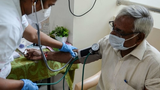 A medical worker checks the blood pressure of a man after he was inoculated with a Covid-19 vaccine at a government hospital in Chennai on March 1. Six states and UTs, including Maharashtra, Kerala, Goa, Chandigarh, Punjab and Gujarat, have a weekly positivity rate higher than the national average of 2%, HT reported.(Arun Sankar / AFP)