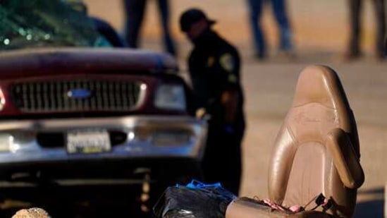 A law enforcement officer examines the scene of a deadly crash in Holtville, California.(AP) A law enforcement officer examines the scene of a deadly crash in Holtville, California.(AP)