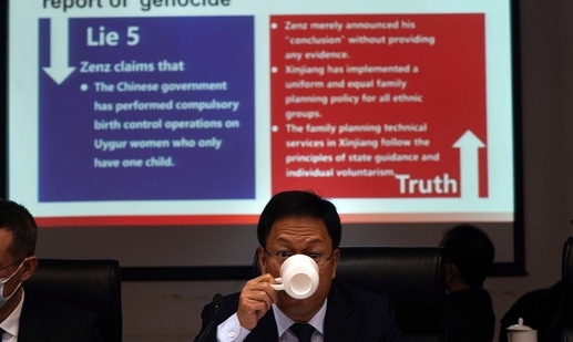 Xu Guixiang, a deputy spokesperson for the Xinjiang regional government, drinks from a cup near a slide refuting claims of genocide during a press conference in Beijing, China.(AP Photo) Xu Guixiang, a deputy spokesperson for the Xinjiang regional government, drinks from a cup near a slide refuting claims of genocide during a press conference in Beijing, China.(AP Photo)