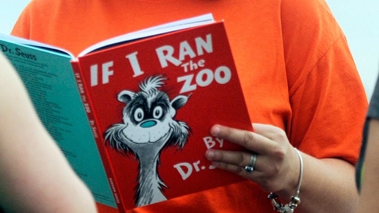 FILE - In this Sept. 24, 2013, file photo, Courtney Keating, education coordinator of The Literacy Center in Evansville, Ind., reads "If I Ran the Zoo," By Dr. Seuss, to passersby during an event to promote literacy along the Evansville Riverfront. Dr. Seuss Enterprises, the business that preserves and protects the author and illustrator's legacy, announced on his birthday, Tuesday, March 2, 2021, that it would cease publication of several children's titles including "And to Think That I Saw It on Mulberry Street" and "If I Ran the Zoo," because of insensitive and racist imagery.(AP) FILE - In this Sept. 24, 2013, file photo, Courtney Keating, education coordinator of The Literacy Center in Evansville, Ind., reads "If I Ran the Zoo," By Dr. Seuss, to passersby during an event to promote literacy along the Evansville Riverfront. Dr. Seuss Enterprises, the business that preserves and protects the author and illustrator's legacy, announced on his birthday, Tuesday, March 2, 2021, that it would cease publication of several children's titles including "And to Think That I Saw It on Mulberry Street" and "If I Ran the Zoo," because of insensitive and racist imagery.(AP)