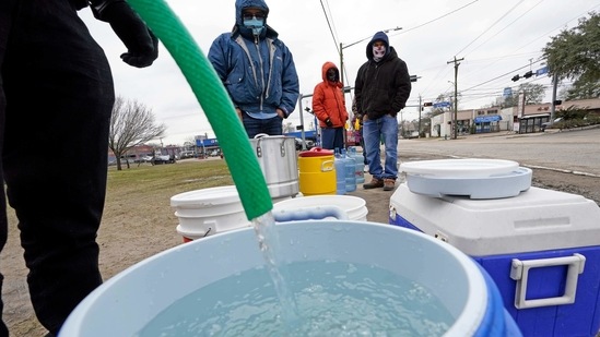 FILE - In this Feb. 18, 2021, file photo, a water bucket is filled as others wait in near freezing temperatures to use a hose from public park spigot in Houston. The snow and ice that crippled some states across the South has melted. But it has exposed the fragility of aging waterworks that experts have been warning about for years. Cities across Texas, Tennessee, Louisiana and Mississippi are still grappling with outages that crippled health care facilities and forced families to wait in line for potable water. (AP Photo/David J. Phillip, File)(AP)