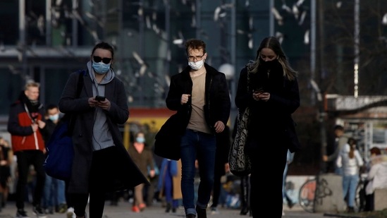 People wearing protective masks amid the outbreak of coronavirus disease (Covid-19) walk in the centre of Warsaw, Poland. (REUTERS)