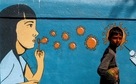 A boy walks past a graffiti amidst the spread of the coronavirus disease (COVID-19) on a street in Navi Mumbai(Reuters) A boy walks past a graffiti amidst the spread of the coronavirus disease (COVID-19) on a street in Navi Mumbai(Reuters)
