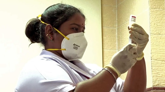 A healthcare worker fills the syringe while vaccinating in Delhi hospital. A healthcare worker fills the syringe while vaccinating in Delhi hospital.