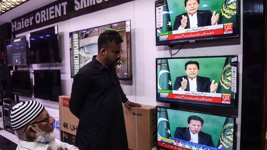 Shopkeepers listen to Pakistan's Prime Minister Imran Khan addressing the nation on television, in Karachi. (AFP. ) Shopkeepers listen to Pakistan's Prime Minister Imran Khan addressing the nation on television, in Karachi. (AFP. )