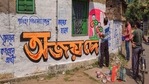 A TMC supporter paints a wall to campaign for the party ahead of Assembly polls, in Nadia.(PTI)