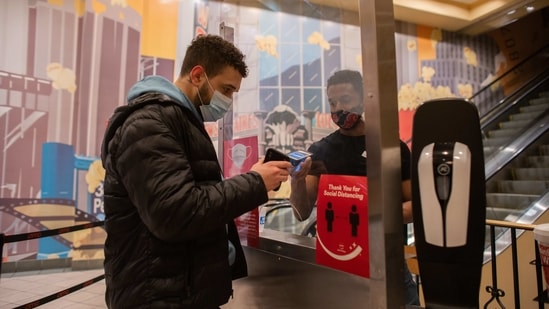 A worker, right, scans an electronic ticket on a smartphone at an AMC movie theater in New York, US on Friday. (Bloomberg Photo ) A worker, right, scans an electronic ticket on a smartphone at an AMC movie theater in New York, US on Friday. (Bloomberg Photo )