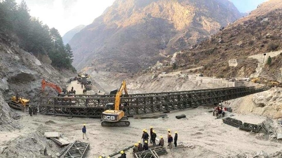 Border Roads Organisation (BRO) workers engaged in building a valley bridge over the Rishi Ganga River at Raini village of the disaster-hit Chamoli district. (PTI)(HT_PRINT)