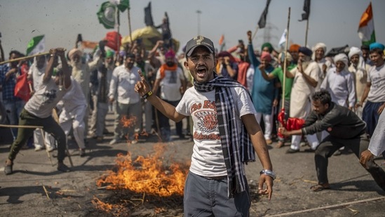A demonstrator shouts slogans as a mock corpse representing Prime Minister Narendra Modi burns in the background, while farmers block a highway on March 6. The demonstrations demand a rollback of the Farmers' Produce Trade and Commerce (Promotion and Facilitation) Act, 2020; Farmers' (Empowerment and Protection) Agreement on Price Assurance and Farm Services Act, 2020; and Essential Commodities (Amendment) Act, 2020.(Altaf Qadri/AP)