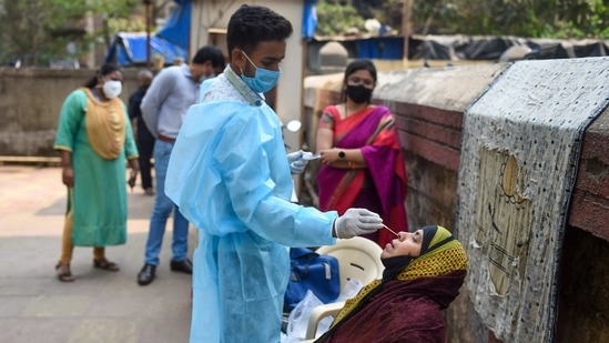A health worker takes swab sample of a resident for Covid-19 testing in a housing society, amid a surge in coronavirus cases, at Nehru Nagar in Mumbai.(PTI) A health worker takes swab sample of a resident for Covid-19 testing in a housing society, amid a surge in coronavirus cases, at Nehru Nagar in Mumbai.(PTI)
