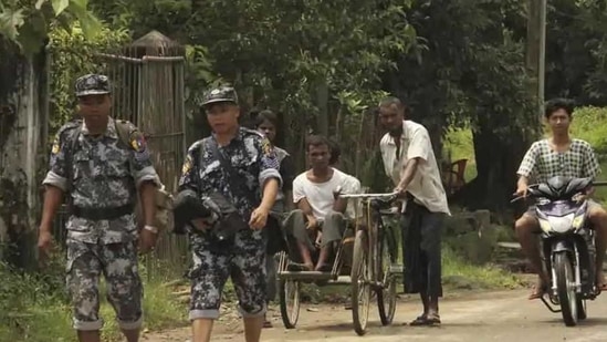 Myanmar Border Guard Police walk ahead of a trishaw driver and passenger along the main road of Buthidaung, northern Rakhine state of Myanmar, on September 6, 2017.(AP file photo for representation purpose) Myanmar Border Guard Police walk ahead of a trishaw driver and passenger along the main road of Buthidaung, northern Rakhine state of Myanmar, on September 6, 2017.(AP file photo for representation purpose)