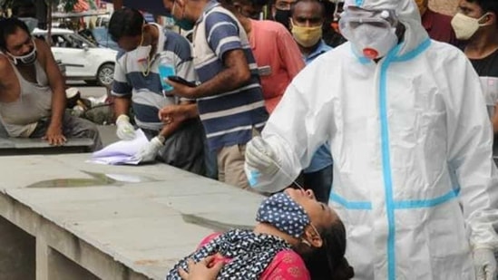 Health worker in PPE kit collects swab sample at the market at Boring road for Covid 19 test, in Patna, Bihar.