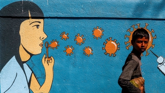 A boy walks past a graffiti amidst the spread of the coronavirus disease (Covid-19) on a street in Navi Mumbai. (Reuters File Photo )
