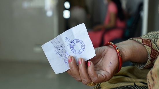 A senior citizen holding a token during a vaccination drive at District Hospital, Sector 30, in Noida on March 6. In the second phase of the vaccination drive, which commenced on March 1, people above 60 years of age and those above 45 and with specified co-morbid conditions are being vaccinated.(Sunil Ghosh / HT Photo)