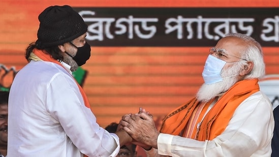 Prime Minister Narendra Modi exchanges greetings with Bollywood actor Mithun Chakraborty after he joined BJP during a public meeting ahead of West Bengal Assembly Polls, at Brigade Parade Ground in Kolkata. (PTI Photo)