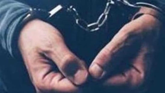 Arrested computer hacker and cyber criminal with handcuffs, close up of hands (Getty Images/iStockphoto)