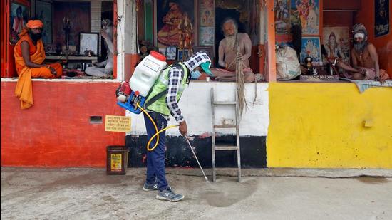 A man wearing a protective mask sprays disinfectant as a preventive measure against the coronavirus disease. (REUTERS)