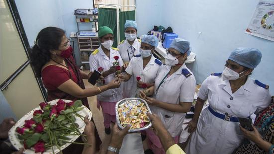 Medical Superintendent of Rajawadi Hospital Dr Vidya Thakur distributes roses and chocolates to staff on the occasion of International Women's Day. (Pratik Chorge/HT Photo)