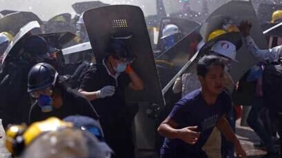 Protesters are dispersed as riot police fire tear gas during a demonstration in Yangon, Myanmar, Monday, March 8, 2021. Myanmar security forces continued to clamp down on anti-coup protesters, firing tear gas to break up a crowd of around 1,000 people who were demonstrating in the capital, Naypyitaw. The protesters deployed fire extinguishers to create a smoke screen as they fled from authorities. (AP Photo)(AP) Protesters are dispersed as riot police fire tear gas during a demonstration in Yangon, Myanmar, Monday, March 8, 2021. Myanmar security forces continued to clamp down on anti-coup protesters, firing tear gas to break up a crowd of around 1,000 people who were demonstrating in the capital, Naypyitaw. The protesters deployed fire extinguishers to create a smoke screen as they fled from authorities. (AP Photo)(AP)