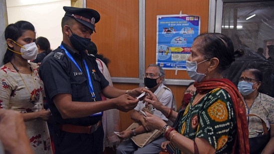 An elderly woman interacts with a security personnel during a Covid-19 vaccination drive, at NMMC Hospital in Vashi, Navi Mumbai.(Bachchan Kumar / HT Photo)