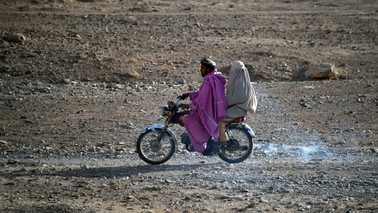 A man rides a motorbike with a woman wearing a burqa sitting behind along a road in the Arghandab district of Kandahar province.(AFP) A man rides a motorbike with a woman wearing a burqa sitting behind along a road in the Arghandab district of Kandahar province.(AFP)