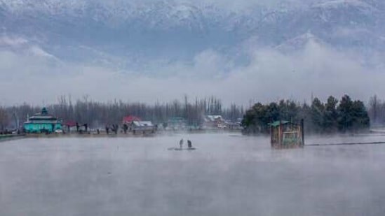 Men row their makeshift raft made of plastic pipes on the Dal Lake.(AP) Men row their makeshift raft made of plastic pipes on the Dal Lake.(AP)
