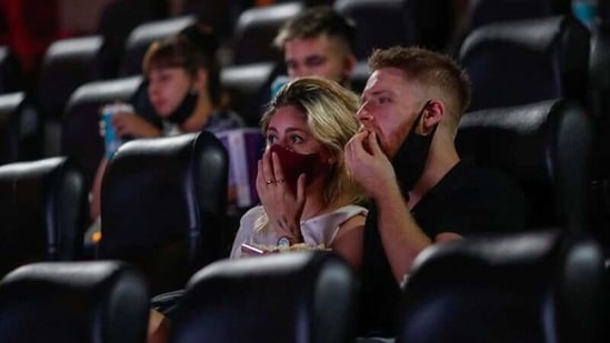 People wearing protective face masks are seen inside a movie theater, as cinemas in Argentina reopen amid an easing of new coronavirus disease (Covid-19) infections, in Buenos Aires, Argentina March 3, 2021. (Reuters)