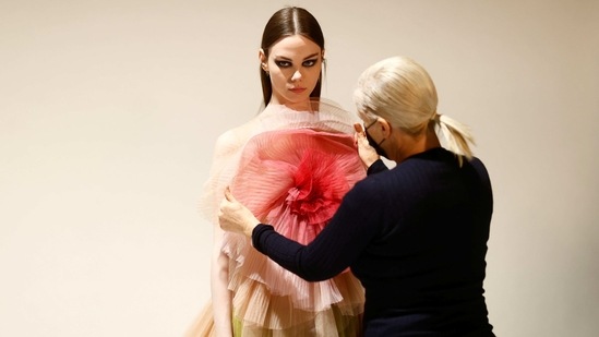 Maria Grazia Chiuri, designer for Fashion house Dior, poses with a model during an interview with Reuters ahead of her Fall/Winter 2021 collection presentation in a digital format during Paris Fashion week, in Aubervilliers, near Paris, France, March 6, 2021.  (REUTERS)