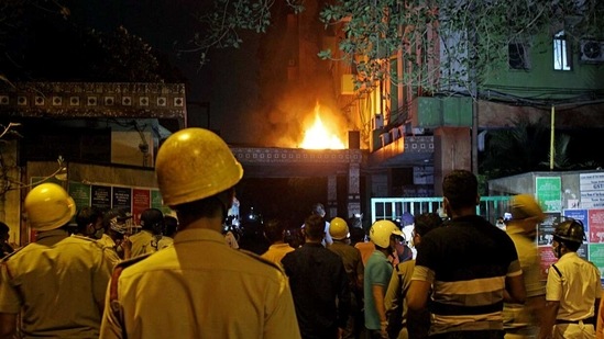 Firefighters and locals stand and watching fire after it broke out on the 13th floor of a multi-storeyed building and housing offices of the Railways, on Strand Road in Kolkata on Monday. (ANI Photo) Firefighters and locals stand and watching fire after it broke out on the 13th floor of a multi-storeyed building and housing offices of the Railways, on Strand Road in Kolkata on Monday. (ANI Photo)