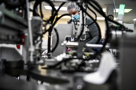 Employees work as they make respiratory masks in a family-owned medical equipment factory in north Miami, Florida on February 15, 2021(AFP)