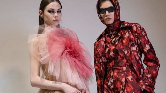 Two models present creations for Christian Dior during the presentation of the Fall/Winter 2021 ready-to-wear fashion collection, on March 6, 2021, in Aubervilliers, on the outskirts of Paris. (AFP)