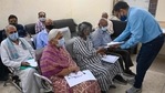 A medical worker examines the documents of an elderly who arrived to get a jab of Covid-19 coronavirus vaccine at vaccination centre in New Delhi. (AFP) A medical worker examines the documents of an elderly who arrived to get a jab of Covid-19 coronavirus vaccine at vaccination centre in New Delhi. (AFP)