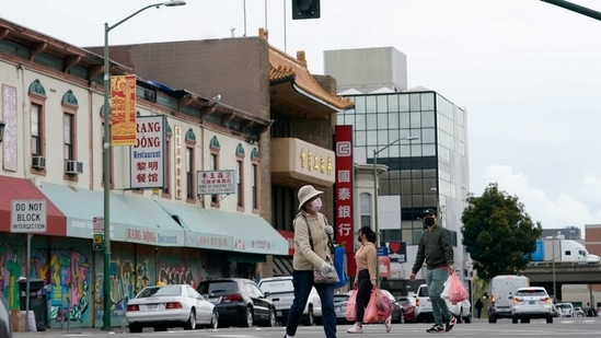 People wear face masks while crossing a street in China(AP)