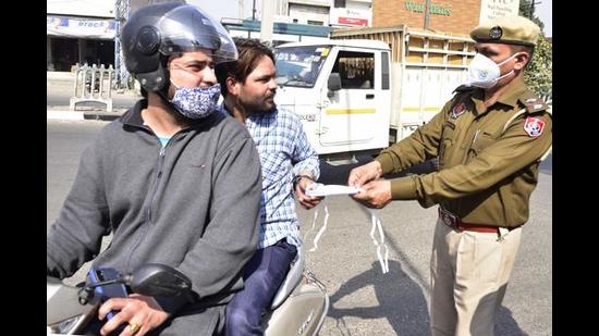 Cops distributing masks to commuters during a drive in February. (HT FILE) Cops distributing masks to commuters during a drive in February. (HT FILE)
