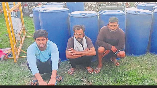 The accused along with drums of raw material used for making liquor at Durana village on Wednesday. (HT PHOTO)