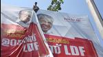 A worker puts up an election campaign banner of Kerala chief minister Pinarayi Vijayan, in Kochi on March 5. (File photo)