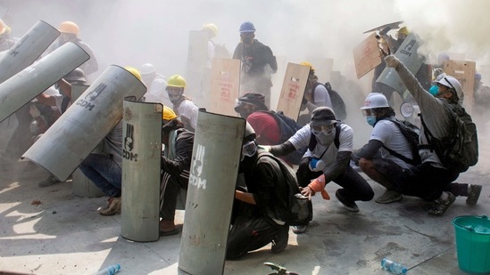 Protesters take cover as they clash with riot police officers during a protest against the military coup in Yangon, Myanmar (Reuters) Protesters take cover as they clash with riot police officers during a protest against the military coup in Yangon, Myanmar (Reuters)