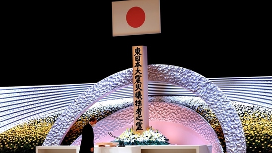 Japan's Prime Minister Yoshihide Suga bows in front of the altar for victims of the March 11 earthquake and tsunami at the national memorial service on the 10th anniversary of the disaster, in Tokyo, Japan on March 11, 2021.(Behrouz Mehri via REUTERS)