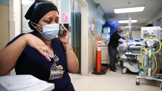LOS ANGELES, CALIFORNIA - FEBRUARY 17: (EDITORIAL USE ONLY) Senior chaplain Andrea Cammarota speaks with a patient's family in the Emergency Department at Providence Holy Cross Medical Center in the Mission Hills neighborhood on February 17, 2021 in Los Angeles, California. The hospital is located in the northeast San Fernando Valley, which was a primary coronavirus hotspot in hard hit Los Angeles County. The patient population is predominantly from the Latinx community. In the US overall, Latinos are 3.2 times more likely to have been hospitalized as whites due to COVID, according to the latest CDC data. Increased chances of exposure to the virus, social determinants of health, economic and systemic inequities all contribute to heightened coronavirus risk.   Mario Tama/Getty Images/AFP
== FOR NEWSPAPERS, INTERNET, TELCOS & TELEVISION USE ONLY == (AFP)