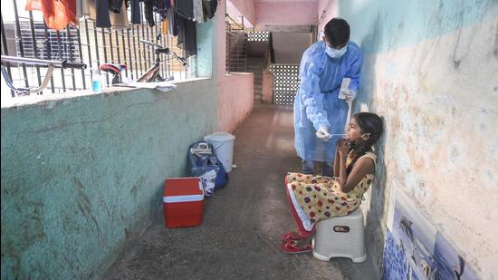 A health worker collects swab sample of a girl at Dharavi. (FILE) A health worker collects swab sample of a girl at Dharavi. (FILE)