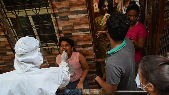 A health worker wearing protective gear takes a swab sample of a resident for a Covid-19 coronavirus test at Dharavi slum in Mumbai on March 11, 2021. (Photo by Punit PARANJPE / AFP) (AFP) A health worker wearing protective gear takes a swab sample of a resident for a Covid-19 coronavirus test at Dharavi slum in Mumbai on March 11, 2021. (Photo by Punit PARANJPE / AFP) (AFP)