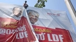 A worker puts up an election campaign banner of Kerala chief minister Pinarayi Vijayan, in Kochi