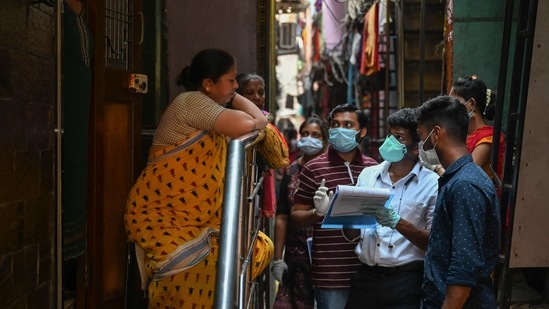 Health workers interact with residents during a door-to-door Covid-19 screening drive, at Dharavi, in Mumbai, on March 11. Mumbai reported a 141-day high (since October 21) with 1,509 new infections.(Punit Paranjpe / AFP)
