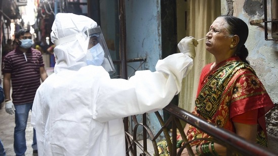 A health worker collects a swab sample from an elderly woman for Covid-19 test, at Dharavi, in Mumbai, on March 11. Active cases in Maharashtra also went past the grim landmark of 100,000 as the count stood at 106,070 on March 11.(Kunal Patil / PTI)