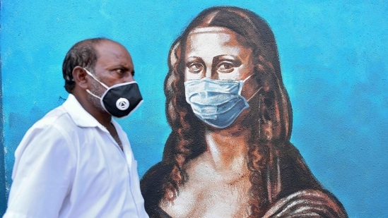 A pedestrian walks past a mural of Leonardo Da Vinci's "Mona Lisa" wearing a face mask, in Mumbai, on March 10. Maharashtra reported 57 fatalities, while the case fatality rate (CFR) stood at 2.32% on March 11.(Indranil Mukherjee / AFP)