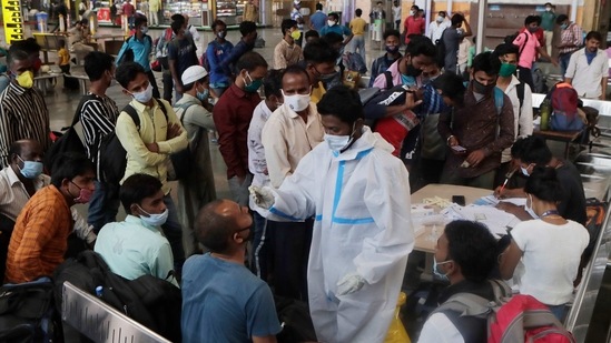 A health worker collects swab samples from trevellers, at Chhatrapati Shivaji Maharaj Terminus, in Mumbai, on March 10. Of the deaths reported on March 11, 25 occurred in the past 48 hours and 19 in the past week. The remaining 13 deaths were from the period before last week.(Rajanish Kakade / AP)
