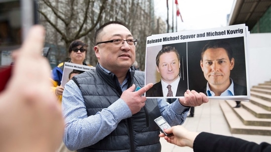 Louis Huang of Vancouver Freedom and Democracy for China holding photos of Canadians Michael Spavor and Michael Kovrig, who are being detained by China, outside British Columbia Supreme Court, in Vancouver.(AFP)