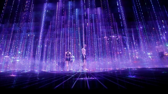 Staffs of teamLab wearing swimming suits walk inside digital artwork combined with light, water and sound during a demonstration of TikTok teamLab Reconnect, digital artwork combined with sauna, ahead of its opening to the public this month in Tokyo, Japan, March 13, 2021. REUTERS/Kim Kyung-Hoon (REUTERS)